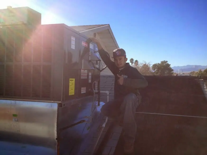HVAC technician performing Heat Pump Repair on a rooftop unit in Gretna